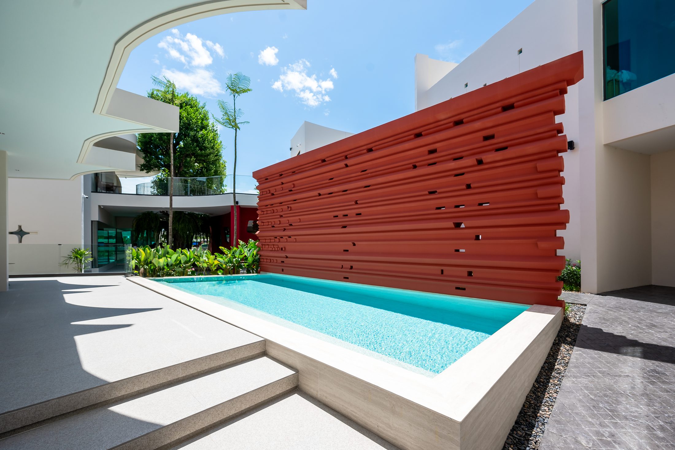 Rachata Ayothaya crimson louvred wall and pool